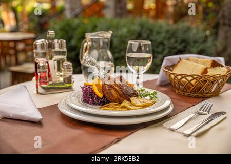Duck leg confit served with roasted pear and red cabbage Stock Photo