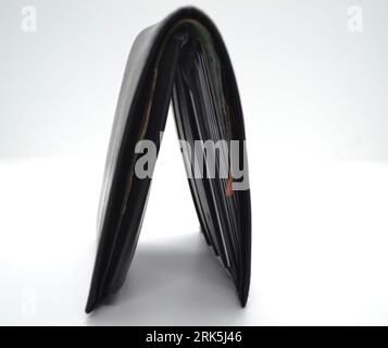 A black leather wallet for guys holds credit cards and cash. Stock Photo