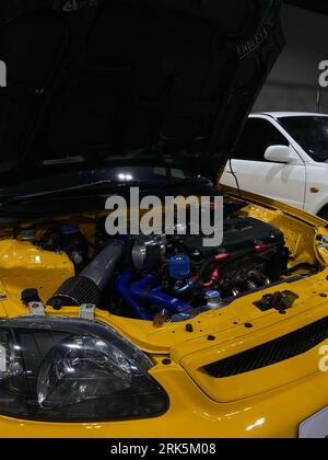 A vertical closeup of a yellow automobile open trunk in an auto salon Stock Photo