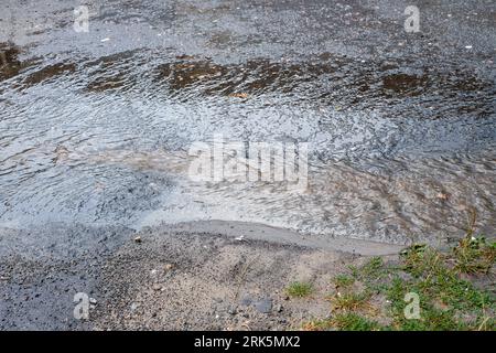 Water flow on the road .Road after winter. Stock Photo