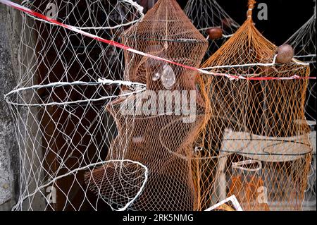 Traditional fishing cast nets with lamps and fishing baskets on a local  shop display in Cefalù Sicily, Italy Stock Photo - Alamy