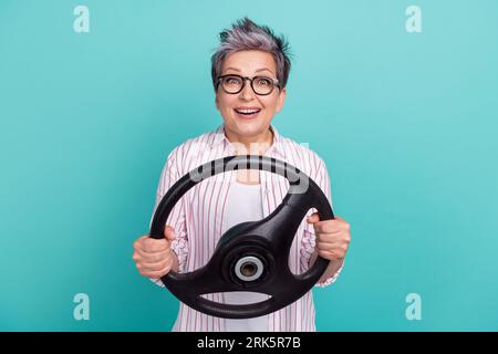 Photo of surprised young woman grey dyed haircut drive steering wheel crazy reaction shock traffic crash isolated on cyan color background Stock Photo