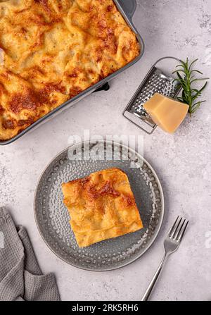 Food photography of lasagna; casserole; cheese; tomato; sauce; parmesan; plate; towel; stand; ground; rustic; italian; meat; mediterranean; pasta; bol Stock Photo