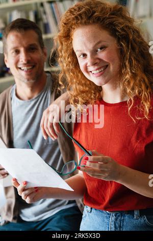 Young manager talking with experienced colleague while using computer in office. Stock Photo