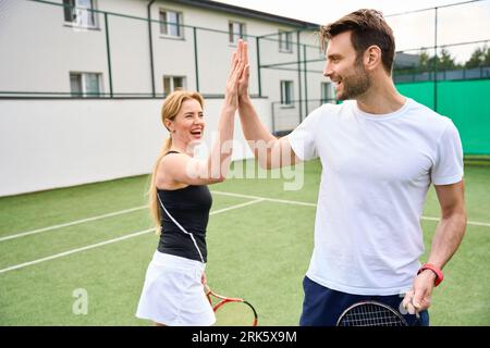 Female and male greet each other on the tennis court Stock Photo