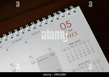 This close-up image features a desk with a calendar on top, surrounded by a modern office setting Stock Photo