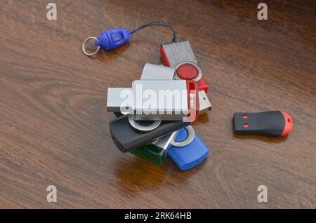 Closeup of several USB sticks on the wooden table. Several different USB sticks. Flash drives representing mobile storage and advanced technology. Stock Photo