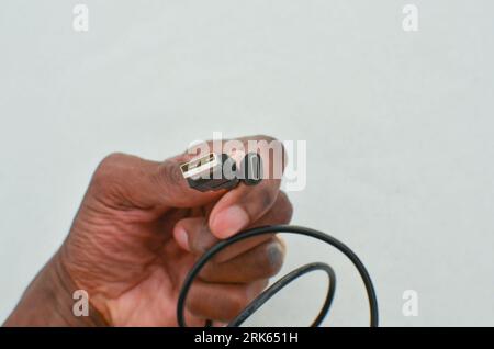 Black USB Type-C cable detail highlighted on a clear surface, perfect for modern technology concepts. Close-up black USB Type-C cable providing speed Stock Photo