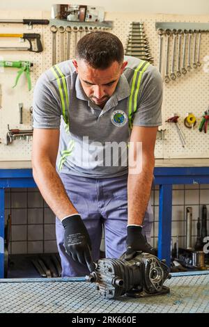 working man in a workshop/factory. man working on metal. metalworking. iron welding and using industrial equipment Stock Photo