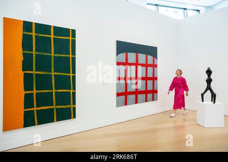 London, UK.  24 August 2023. A staff member passes (L) 'Untitled', 1994, and 'Untitled', 2002, both by Günther Förg and a 1962 Sonja Ferlov Mancoba untitled sculpture at a preview of ‘Legacies of Modernism’, a selling exhibition at Phillips Berkeley Square showcasing works by German multidisciplinary artist Günther Förg from the Mikael Andersen Collection.  The works are on show until 7 September with the sale proceeds contributing to the development of the Sonja Ferlov Mancoba Museum Pavilion on the island of Bornholm, Denmark.  Credit: Stephen Chung / Alamy Live News Stock Photo