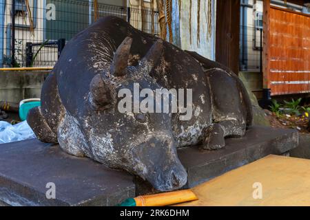 Oita, Japan - Nov 26 2022: Goshingyu, or the sacred ox at a small shrine. It is believed that rubbing its head makes a person smarter Stock Photo