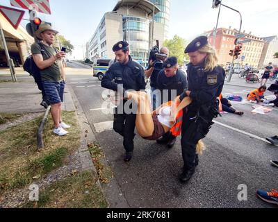 Munich, Bavaria, Germany. 24th Aug, 2023. Police officers carry away activists of the ''Last Generation'' who had previously glued themselves to the pavement in Munich, Germany. (Credit Image: © Sachelle Babbar/ZUMA Press Wire) EDITORIAL USAGE ONLY! Not for Commercial USAGE! Stock Photo