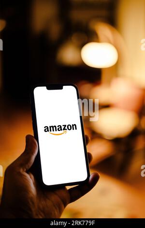 A modern-looking smartphone with an Amazon logo displayed on the screen Stock Photo
