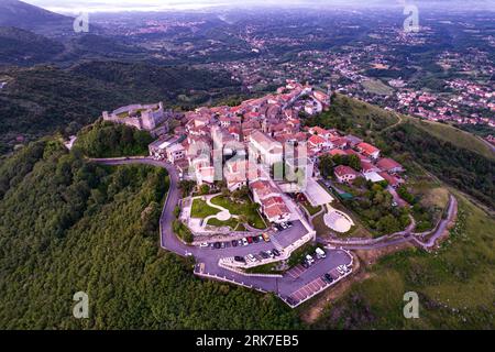 An aerial of a small Italian village with a castle sitting atop a mountain in Castel San Pietro, Italy. Stock Photo