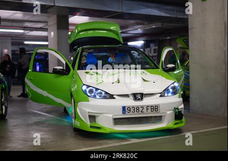 Front view of an old tuned Peugeot 206, it is painted white and green Stock Photo