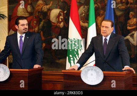 Italian Premier Silvio Berlusconi holds a folder reading