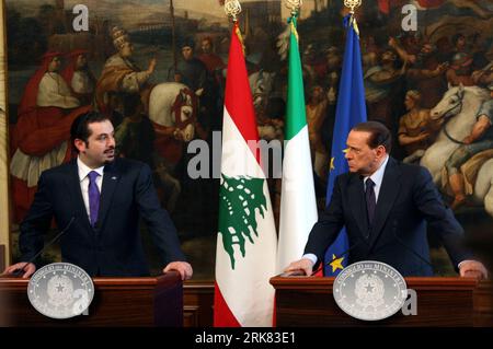 Italian Premier Silvio Berlusconi holds a folder reading