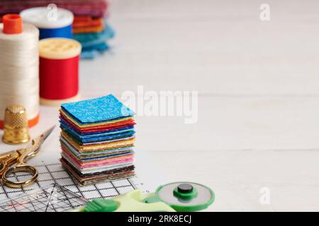 Stack of square pieces of colorful fabrics, accessories for quilting Stock Photo