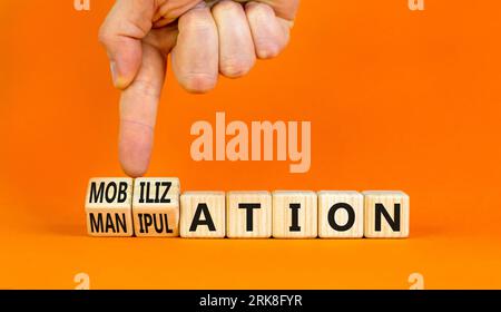 Mobilization or manipulation symbol. Concept words Mobilization Manipulation on wooden cubes. Beautiful orange background. Psychologist hand. Psycholo Stock Photo