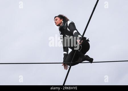 London, UK. 24th Aug, 2023. Internationally renowned tight-rope walker Tatiana Mosio Bongonga on the high wire for the rehearsal performance of her 'Open Lines' show. With the help of twelve extraordinary people drawn from the local community, she makes an astonishing crossing, opening GDIF 2023 tomorrow officially (Greenwich and Docklands International Festival). The one-night-only event tomorrow evening will celebrates the importance of collective togetherness and hope. Credit: Imageplotter/Alamy Live News Stock Photo