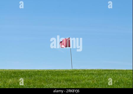 Golf hole waving flag on horizon. Very small golf club Búřov Valašská Bystřice in countryside in Czech republic. Negative space for text. Stock Photo