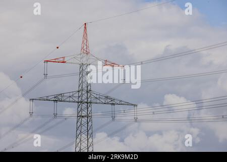 High voltage power lines and electricity pylons forming part of a large electrical transmission network. Stock Photo