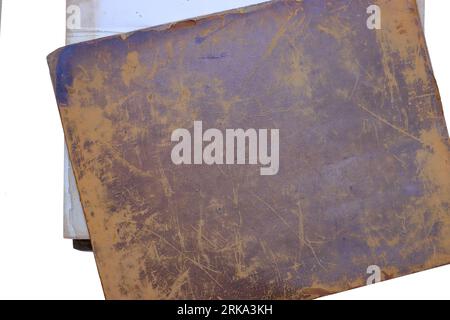Old books: A worn and damaged leather book cover dating from the eighteenth century. The detached leather cover of a book, white background. Stock Photo