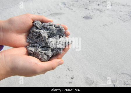 Bildnummer: 54290625  Datum: 11.08.2010  Copyright: imago/Xinhua (100812) -- RIO DE JANEIRO, Aug. 12, 2010 (Xinhua) -- A woman shows sand polluted by oil slick on a beach in the Lakes Region, north of Rio de Janeiro, Brazil, on Aug. 11, 2010. A large oil slick reached beaches along the Atlantic Ocean in the Lakes Region since Aug. 9. Several beaches in Cabo Frio and Arraial do Cabo were affected by the slick, causing more than 10 penguins dead and casting an impact on the local tourism. Rio de Janeiro harbor bureau announced Tuesday that it was ready to start investigations of the 320 ships wh Stock Photo