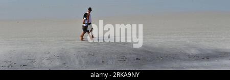 Bildnummer: 54290623  Datum: 11.08.2010  Copyright: imago/Xinhua (100812) -- RIO DE JANEIRO, Aug. 12, 2010 (Xinhua) -- Tourists walk on a beach polluted by oil slick in the Lakes Region, north of Rio de Janeiro, Brazil, on Aug. 11, 2010. A large oil slick reached beaches along the Atlantic Ocean in the Lakes Region since Aug. 9. Several beaches in Cabo Frio and Arraial do Cabo were affected by the slick, causing more than 10 penguins dead and casting an impact on the local tourism. Rio de Janeiro harbor bureau announced Tuesday that it was ready to start investigations of the 320 ships which p Stock Photo