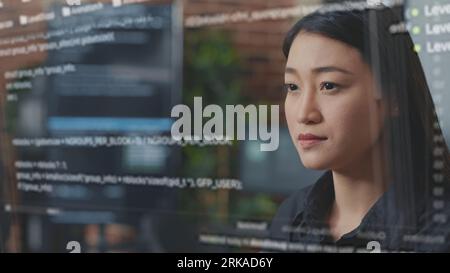 Skilled asian programmer using AR technology to visualize script, writing code on computer screen while in office using Java programming languages. Developer working on fixing database errors Stock Photo