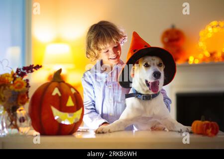 Family carving pumpkin for Halloween celebration. Mother and child cutting jack o lantern for traditional trick or treat decoration. Stock Photo