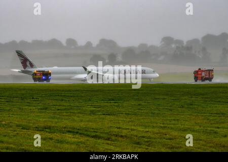 Fire Trucks Follow A7-AND Qatar Airways A350 As It Diverts Into Edinburgh Airport During A Flight From Los Angeles to Doha With A Medical Emergency Stock Photo