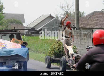 Bildnummer: 54616426  Datum: 07.11.2010  Copyright: imago/Xinhua (101107) -- YOGYAKARTA (INDONESIA), Nov. 7, 2010 (Xinhua) -- A man drives a tractor on his way back to his evacuated home to feed his sheep in the village of Bimomartani, Central Java of Indonesia, on Nov. 7, 2010. Mount Merapi, first started erupting on Oct. 26, has so far killed more than 120 people. (Xinhua/Jin Liangkuai) (nxl) INDONESIA-CENTRAL JAVA-VOLCANO PUBLICATIONxNOTxINxCHN Gesellschaft Naturkatastrophe Vulkanausbruch Vulkan premiumd kbdig xkg 2010 quer  o0  Asche Vulkanasche    Bildnummer 54616426 Date 07 11 2010 Copyr Stock Photo