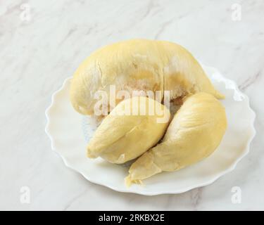 Fresh Durian King of Fruit on White Plate, Above White Table Stock Photo