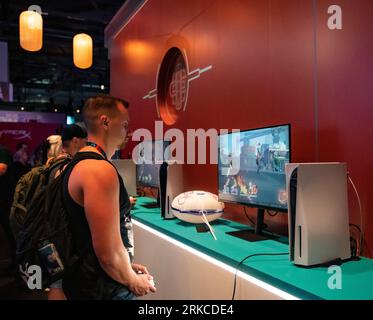 Cologne, Germany. 23rd Aug, 2023. People try games at the booth of miHoYo during gamescom 2023 in Cologne, Germany, Aug. 23, 2023. The 2023 edition of the international computer and video games trade fair gamescom opened on Wednesday in Cologne, western Germany. Chinese companies displayed their products on the trade fair. According to the Koelnmesse, organizer of the week-long event, gamescom is the world's largest trade fair for computer and video games in terms of space and visitors. Credit: Zhang Fan/Xinhua/Alamy Live News Stock Photo