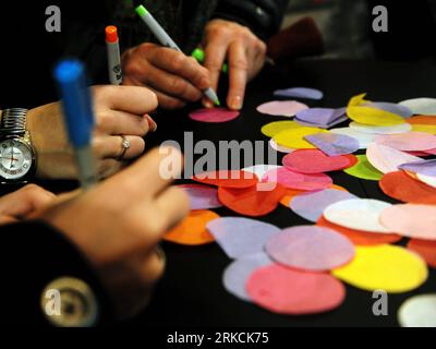 Bildnummer: 54776710  Datum: 29.12.2010  Copyright: imago/Xinhua (101229) -- NEW YORK, Dec. 29, 2010 (Xinhua) -- write their wishes on pieces of confetti in front of the New Year s Eve Wishing Wall at Times Square Information Center in New York, the United States, Dec. 29, 2010. All the pieces of confetti, bearing the best wishes for the year 2011 from around the world, will rain down to revelers during the New Year s Eve celebration on Times Square. (Xinhua/Shen Hong) (wjd) US-NEW YORK-NEW YEAR-WISHING WALL PUBLICATIONxNOTxINxCHN Gesellschaft Vorbereitungen Vorschau Silvesterparty Silvester F Stock Photo