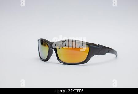 Black sunglasses with yellow-orange glass lenses isolated on white background. Stock Photo