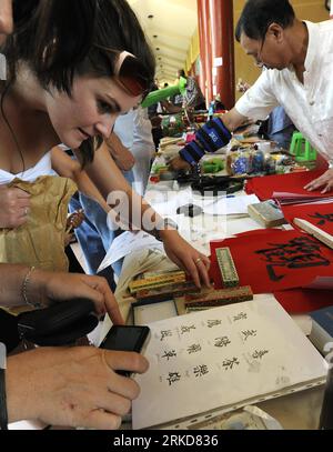 Bildnummer: 54884178  Datum: 06.02.2011  Copyright: imago/Xinhua (110206) -- PRETORIA, Feb. 6, 2011 (Xinhua) -- A South African woman watches Chinese letters at the Chinese New Year Culture Festival held by the Nan Hua Temple in Bronkhorstspruit, South Africa, Feb. 6, 2011. The Chinese New Year Culture Festival held on Sunday has attracted more than 15,000 overseas Chinese and local civilians to enjoy the Chinese culture including watching lion and dragon dances, receiving bonus, tasting Chinese tea and food. (Xinhua/Li Qihua) SOUTH AFRICA-CHINESE NEW YEAR CULTURE FESTIVAL PUBLICATIONxNOTxINxC Stock Photo