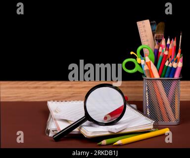 board, books, pencils, opened empty notebook lie on school desk Stock Photo
