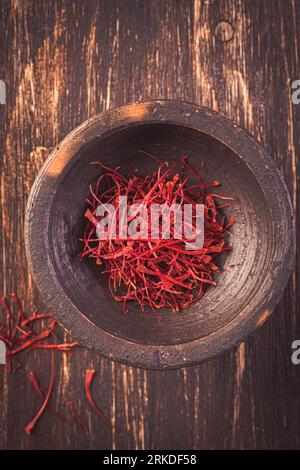 Saffron Spices. Saffron on wooden background. Spice and herbs, seasonings, condiments. Cooking ingredients. Stock Photo
