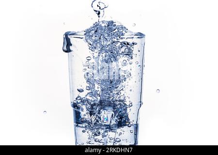 Water splash in a glass on a white background. Water bubbles. Isolated image. Drops of water Stock Photo