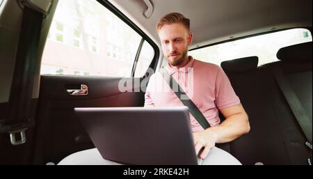 Young Businessman Using Laptop In The Car Stock Photo