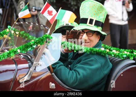 Bildnummer: 55049037  Datum: 21.03.2011  Copyright: imago/Xinhua (110321) -- VANCOUVER, March 21, 2011 (Xinhua) -- Two elder men dressed in green costumes drive classic cars during the parade of St. Patrick s Day in Vancouver, Canada, March 20, 2011. Dozens of performance groups including Irish dancers, kilted pipe bands and dueling sword fighters paraded through Vancouver s downtown at the city s seventh annual St. Patrick s Day Parade Sunday afternoon. (Xinhua/Ma Dan) (zf) CANADA-VANCOUVER-IRELAND-ST PATRICK S DAY-PARADE PUBLICATIONxNOTxINxCHN Gesellschaft Traditionelle Feste St Patricks Day Stock Photo