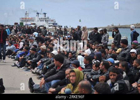 (110330) -- LAMPEDUSA, March 30, 2011 (Xinhua) -- Illegal immigrants from North Africa wait for transfer at the port of Lampedusa island, southernmost Italy, March 29, 2011. Some 18,000 North African immigrants, mainly from unrest-torn Libya and Tunisia, have been flooding the small Italian island of Lampedusa, which is only 110 km away from Africa. More immigrants are expected to land here as the Libyan crisis deepens. Italy will send more ships with a total capacity of 10,000 berths to evacuate migrants on Lampedusa starting from Wednesday. (Xinhua/Wang qingqin) (yc) ITALY-LAMPEDUSA-NORTH AF Stock Photo