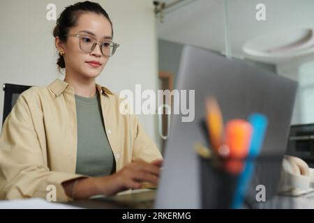 Concentrated devops engineer in glasses deploying updates Stock Photo