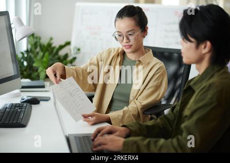 UI designer showing website wireframe to coworker Stock Photo