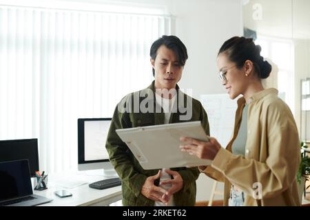 Smiling ui designer showing her ideas to front end developer Stock Photo