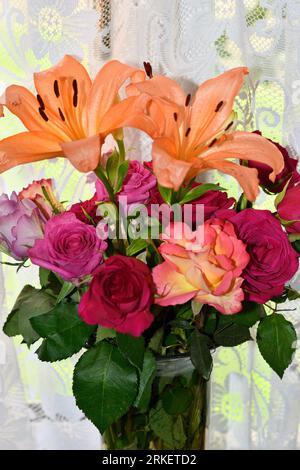 Asiatic Lilies (lilium) with Roses (rosa) indoors in the Summer Months
