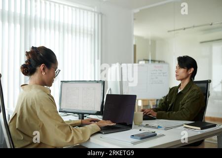 Young woman working in office of successful startup company Stock Photo