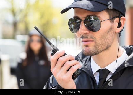Portrait Of A Male Security Guard Talking On Walkie Talkie Stock Photo